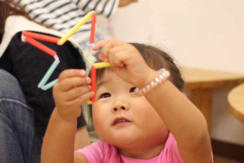 子どもがストローで星を作って遊んでいる様子